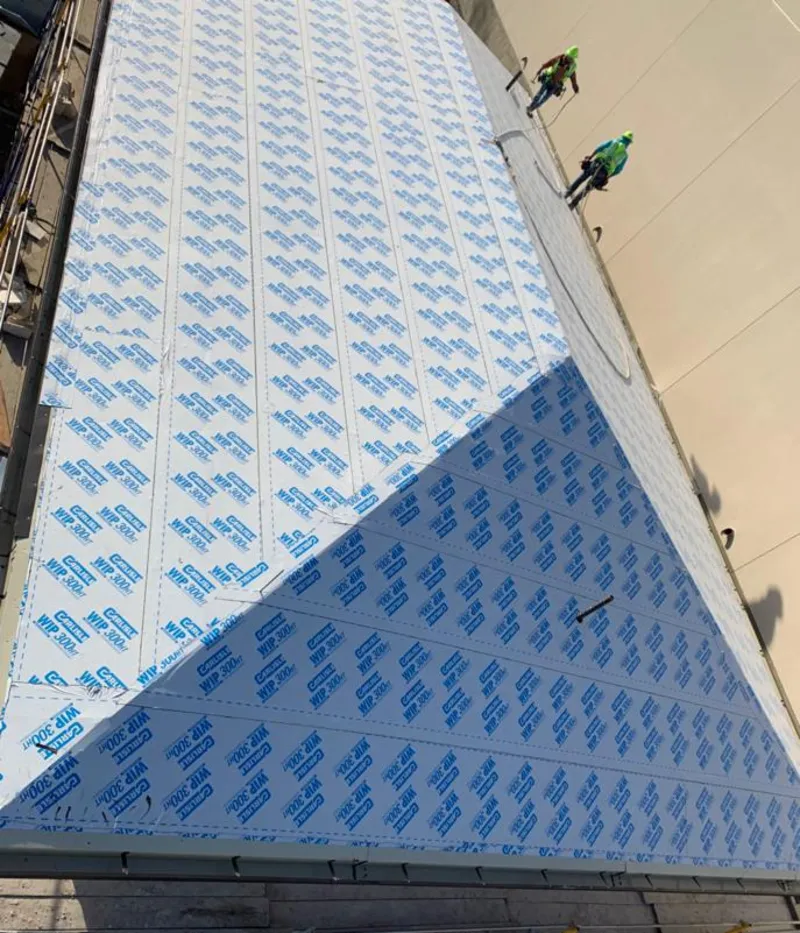 Professional roofers installing underlayment on a metal roof in Suffolk